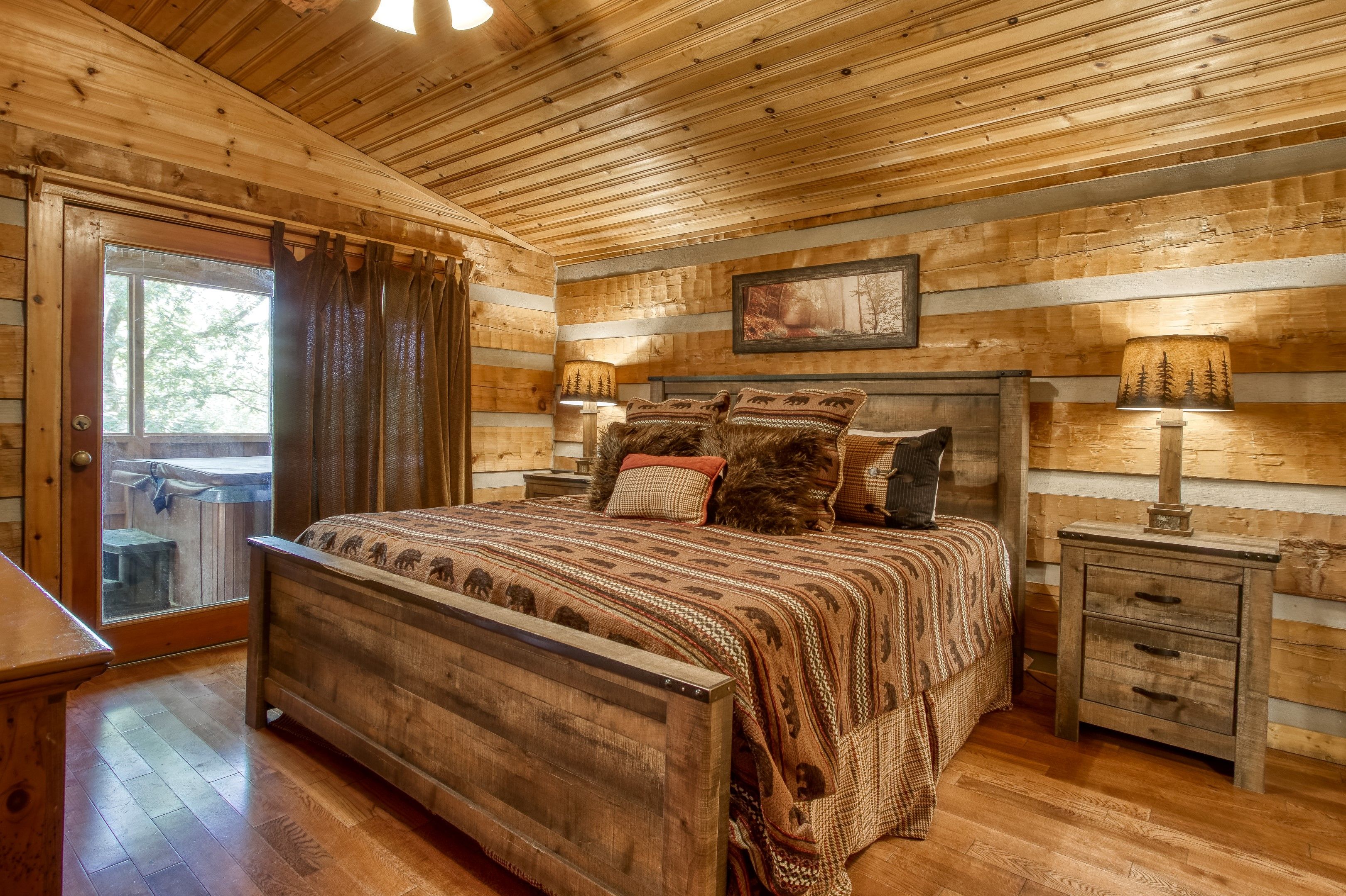 image Dream away in the master suite featuring a king-sized bed, soothing natural decor, and direct access to the private hot tub.