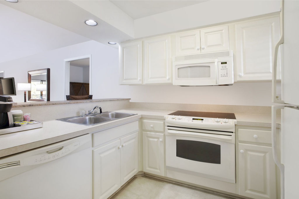 image Crisp white kitchen with modern appliances, ready for your home-cooked meals.