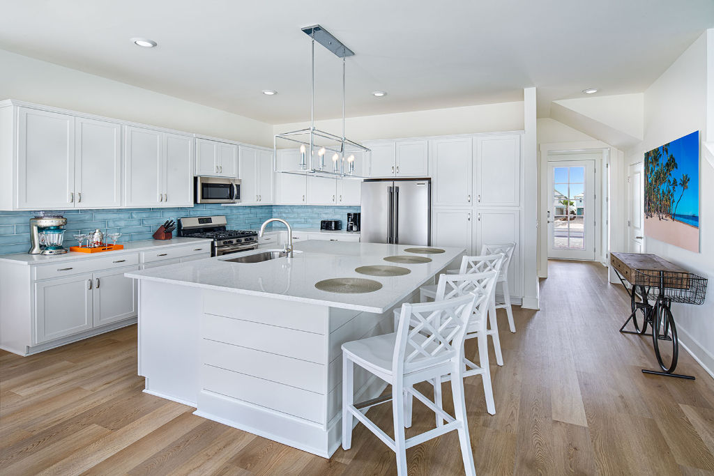 image Sleek, white kitchen with bar seating, perfect for social cooking or quick meals.