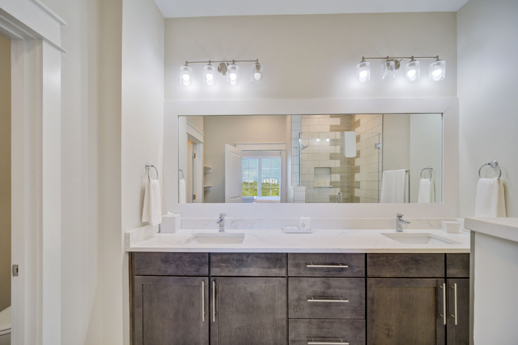 image A welcoming bathroom with rich wooden cabinetry and a dual-sink vanity.