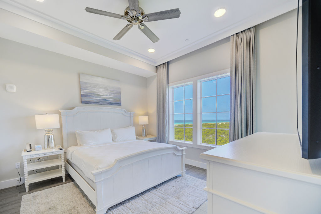 image A spacious bedroom with large windows, inviting in the morning sunshine.