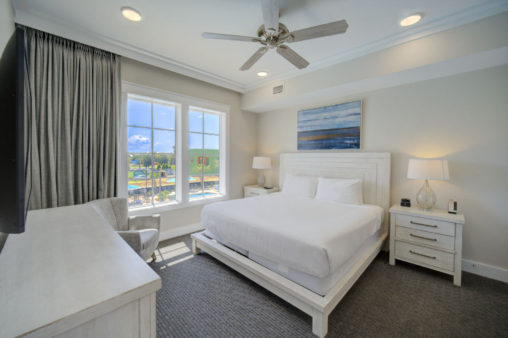 image A bright and inviting bedroom with expansive windows and plush bedding.