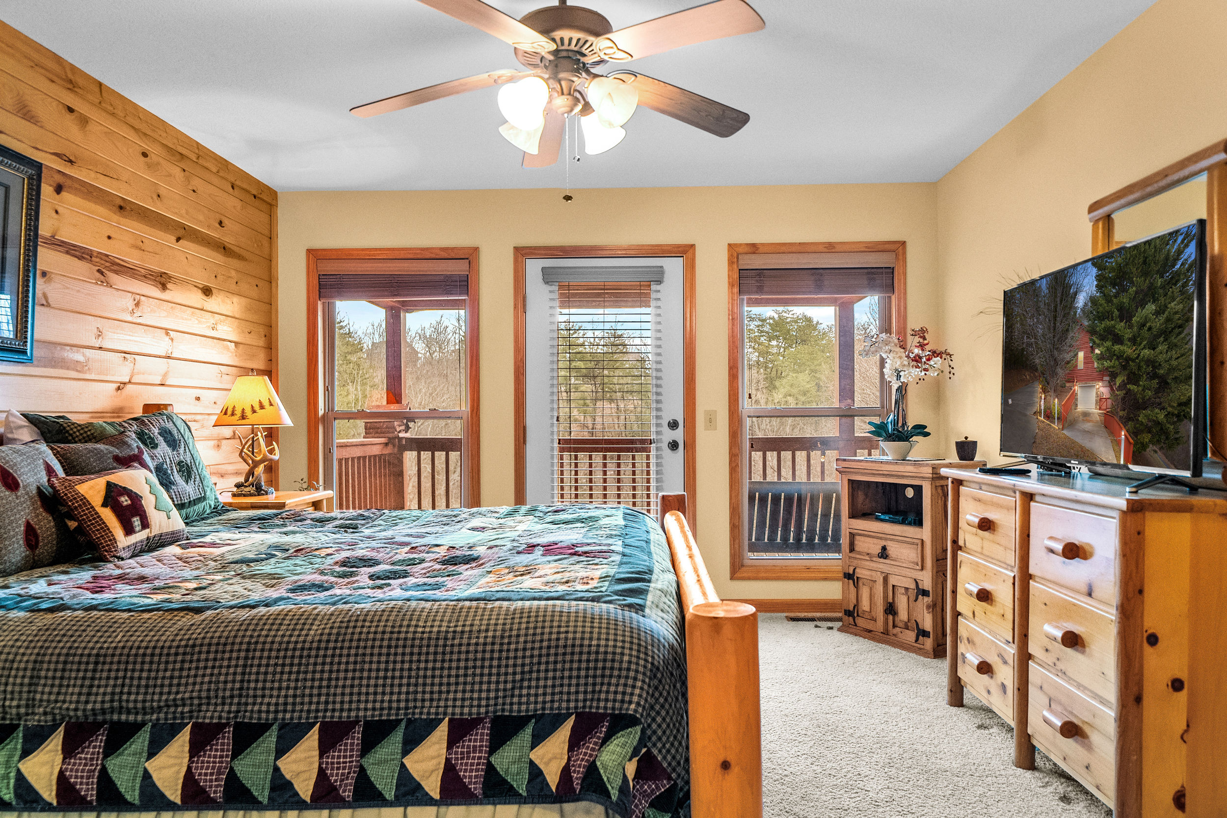 image Rest easy in the master bedroom's luxurious king bed, adorned with a charming quilt, and complete with an ensuite bathroom featuring a shower/bath combo and double sink.