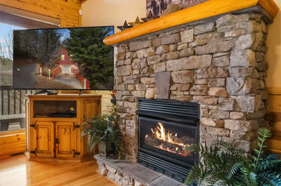 End your day by unwinding in the inviting living area, where the stone fireplace commands the space, providing both warmth and a rustic mountain charm.