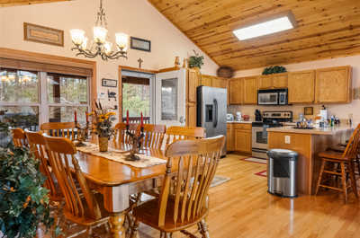 Gather around the spacious dining area, with seating for all your guests, framed by the warm glow of natural wood and rustic charm.