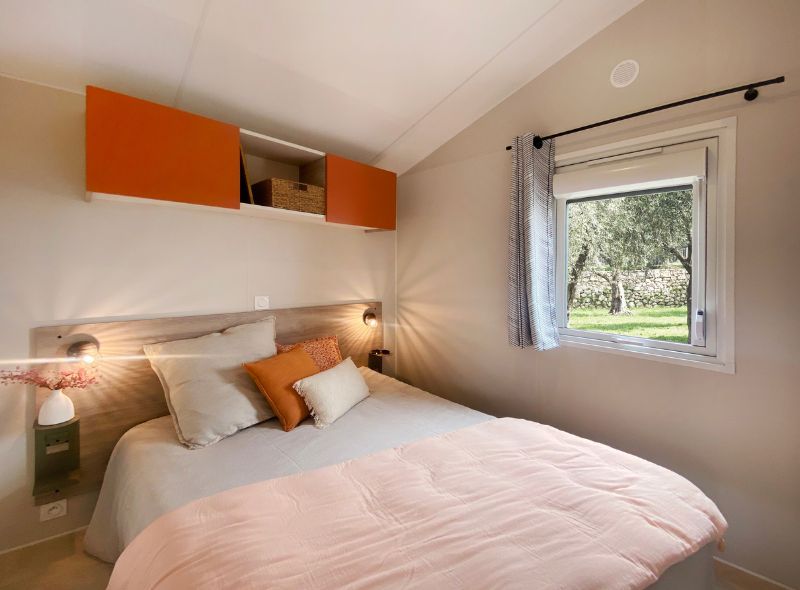 image The bedroom offers a serene atmosphere with a comfortable double bed adorned with plush pillows and soft lighting, creating a restful retreat.