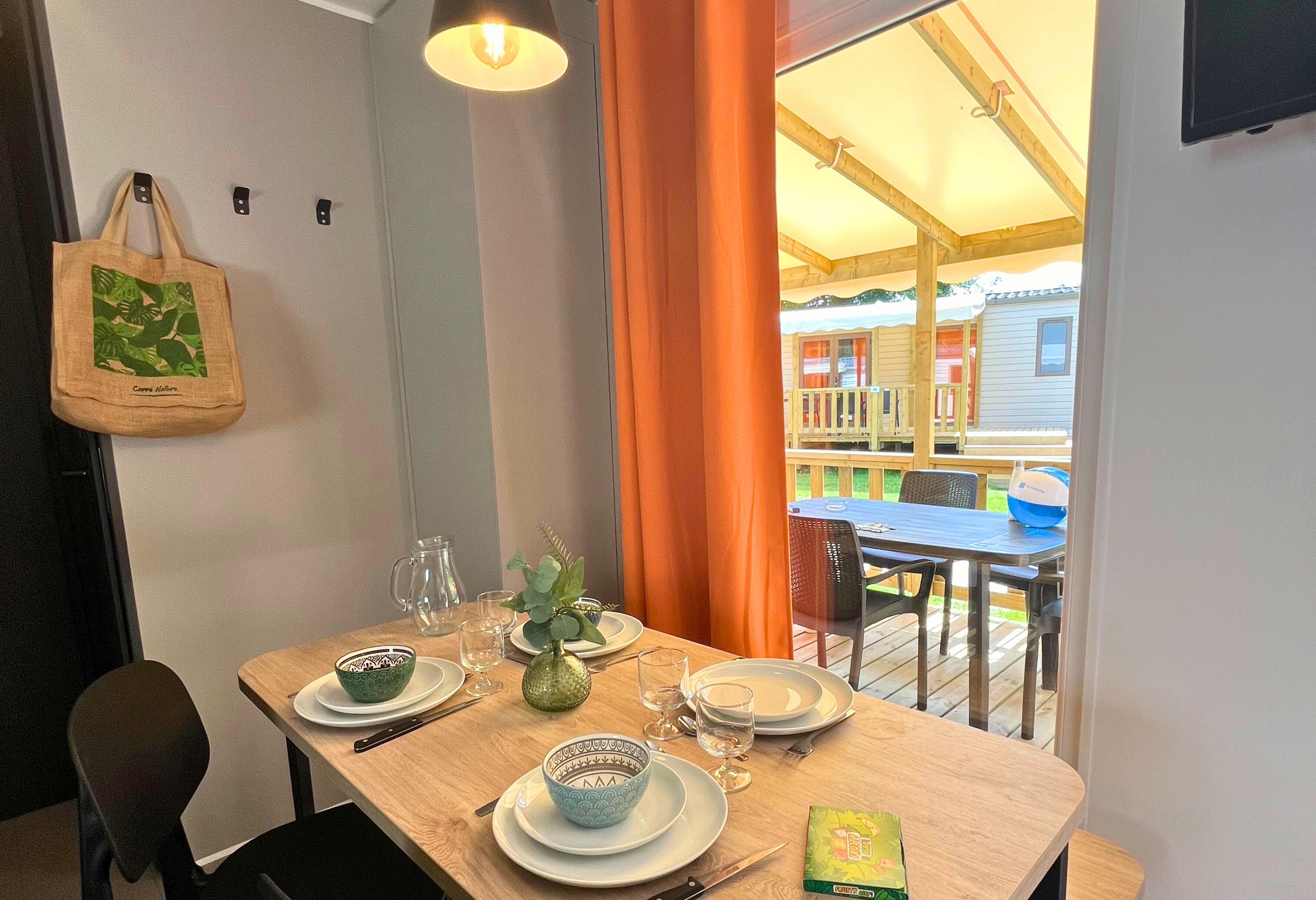 image A welcoming dining nook awaits, styled with warm accents and set for an enjoyable meal indoors or out on the deck.