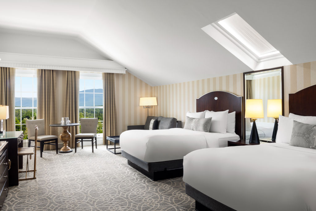 image Experience the height of comfort in our expansive bedroom, complete with a charming sitting area for your leisure.