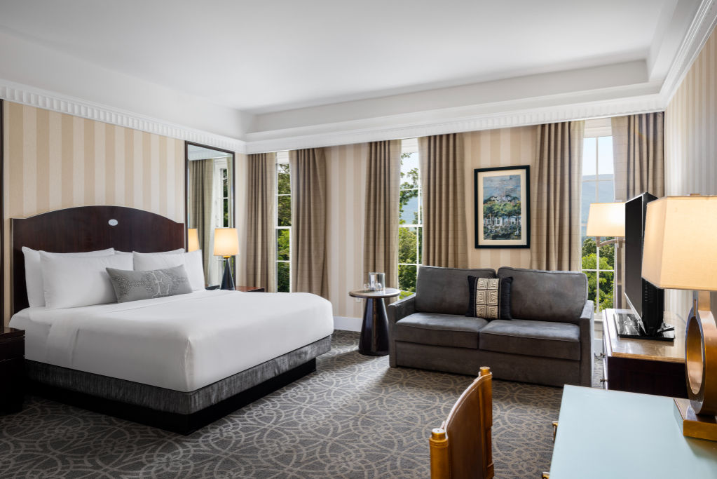 image Unwind in a sumptuous bed with a backdrop of serene elegance and a cozy corner to relax.