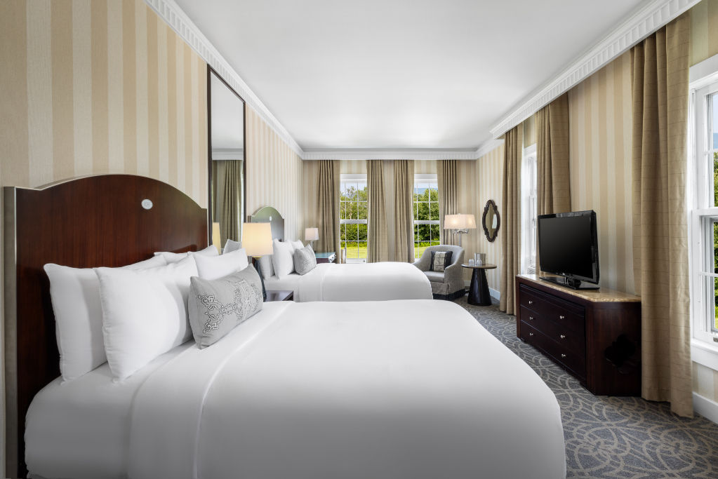 image A grand bedroom that pairs comfort with sophistication, featuring plush linens and a tranquil lounge space.