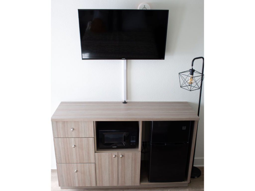 image Functional entertainment and storage unit with a mounted TV.