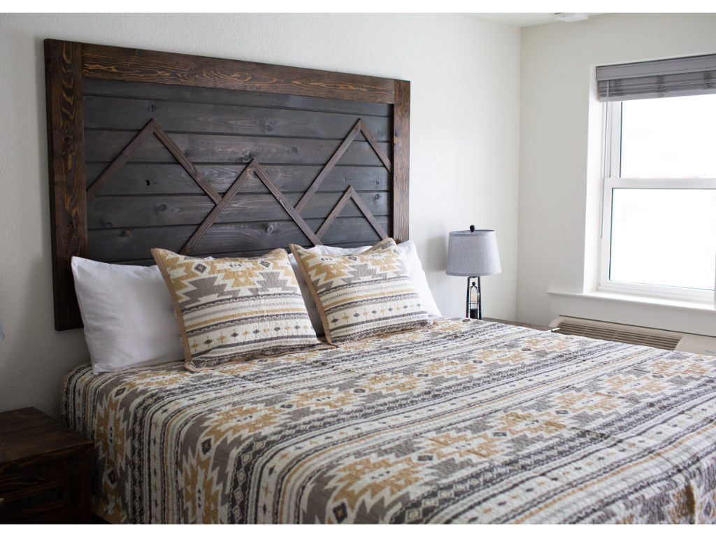 image Bedroom with a textured bedspread and a rustic headboard.