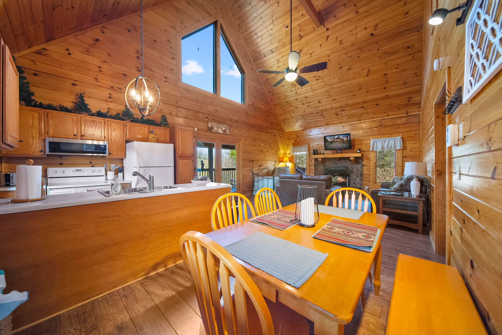 image Gather around the wooden table for a memorable meal in our cabin's inviting dining space, complete with modern appliances and warm interior lighting.