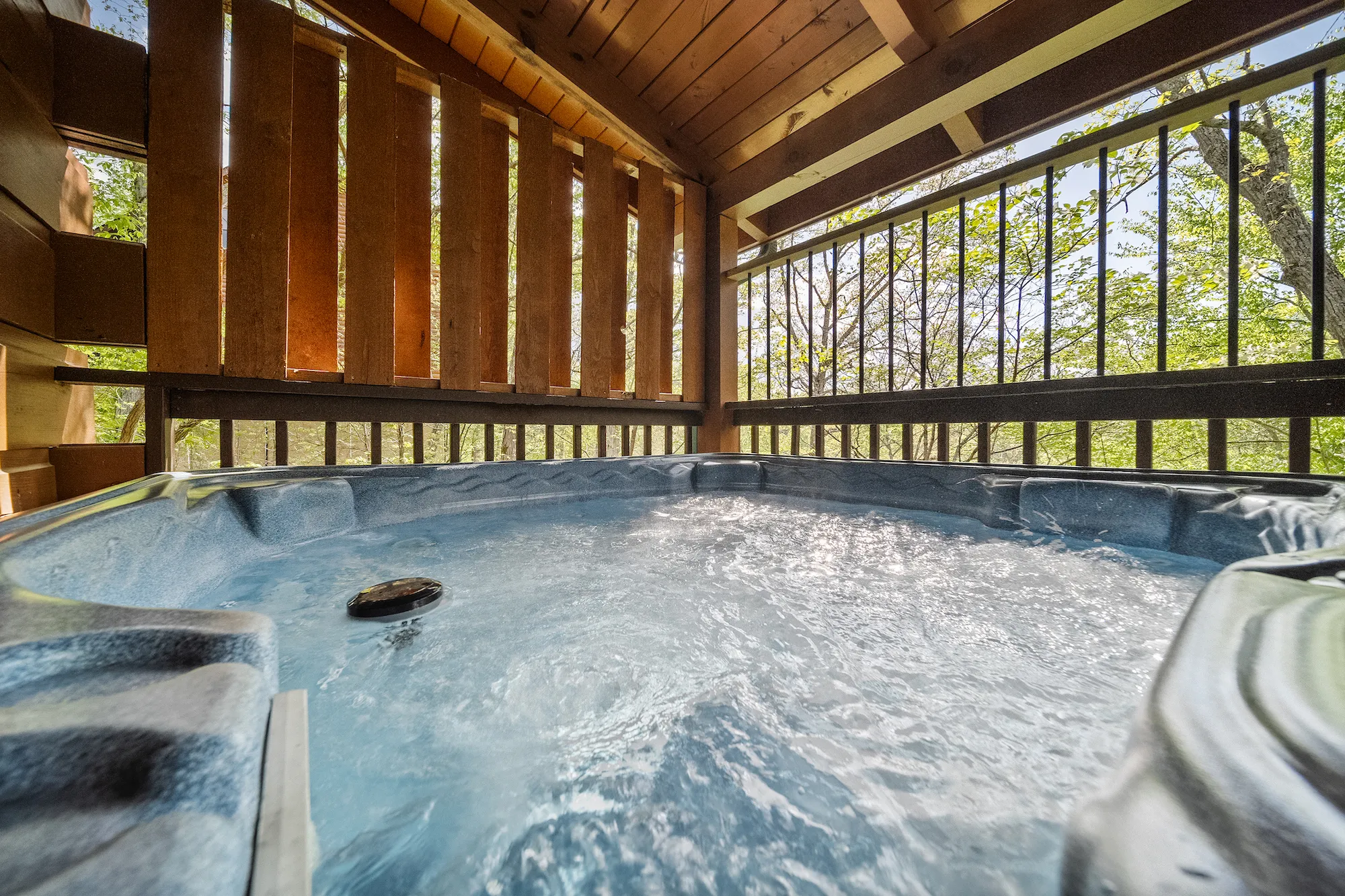 image Indulge in the secluded warmth of our hot tub, designed for relaxation under the canopy of Sevierville’s wooded wonder.