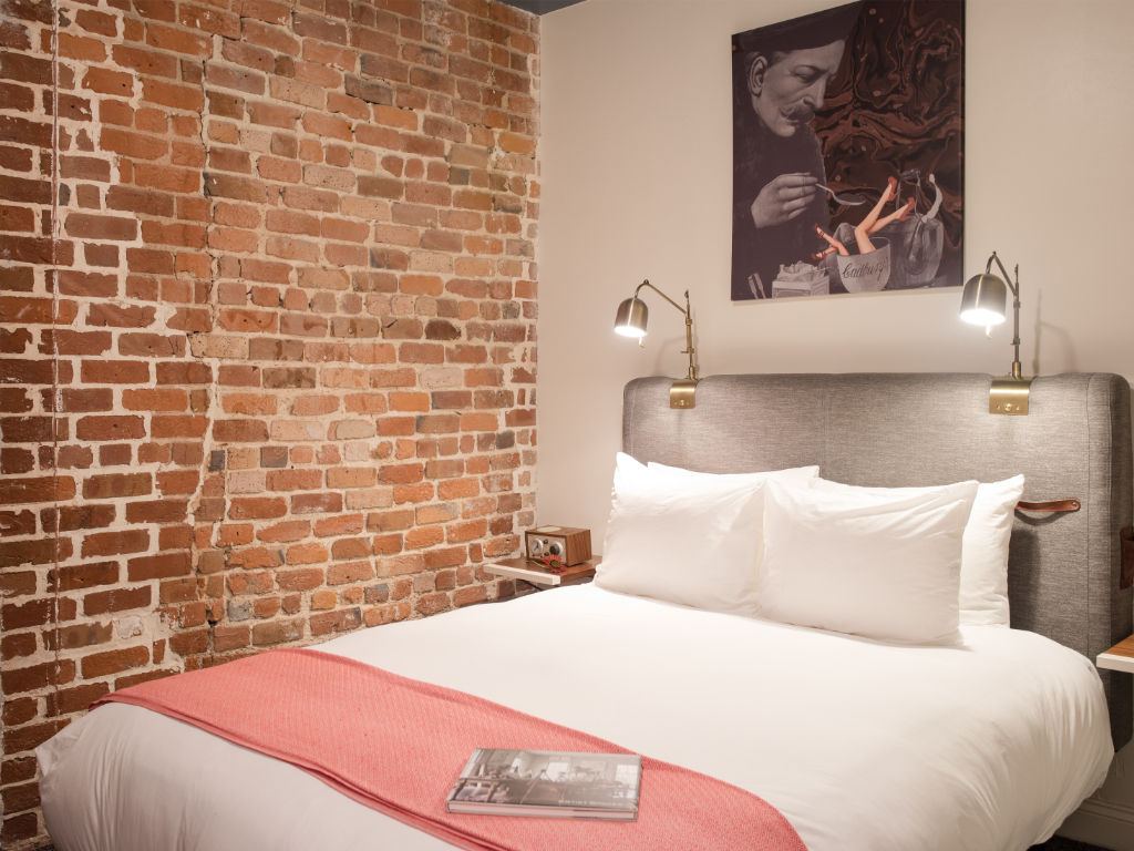image Warm-toned bedroom with brick accent wall and comfortable reading nook