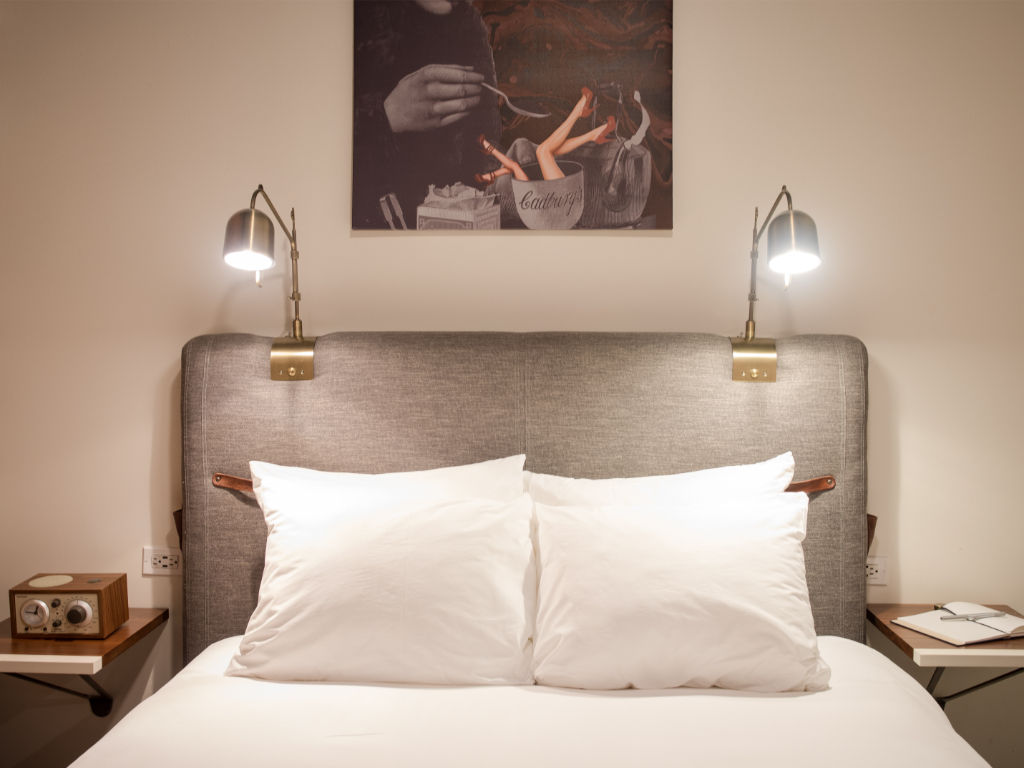 image Cozy bedroom with soft lighting and artistic touches above the headboard