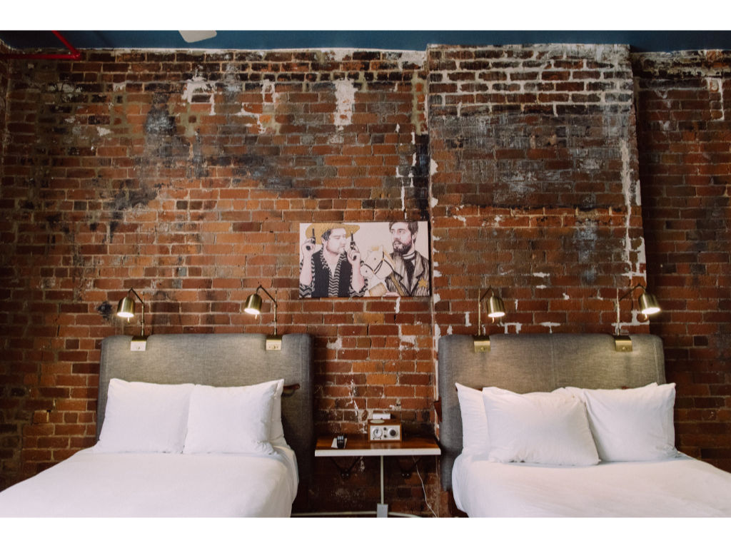 image Rustic brick wall backdrop with elegant white armchairs for a relaxing read