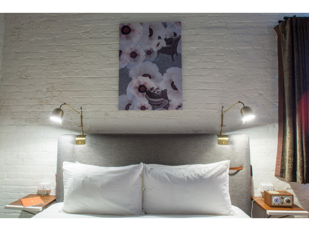 image Tranquil bedroom with white brick backdrop and purple floral art