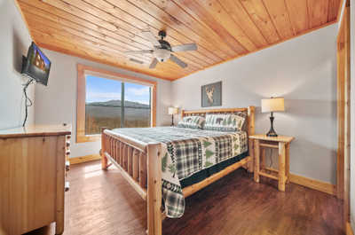 Awake to the beauty of the mountains in this charming bedroom, where every window frames a postcard-worthy view.