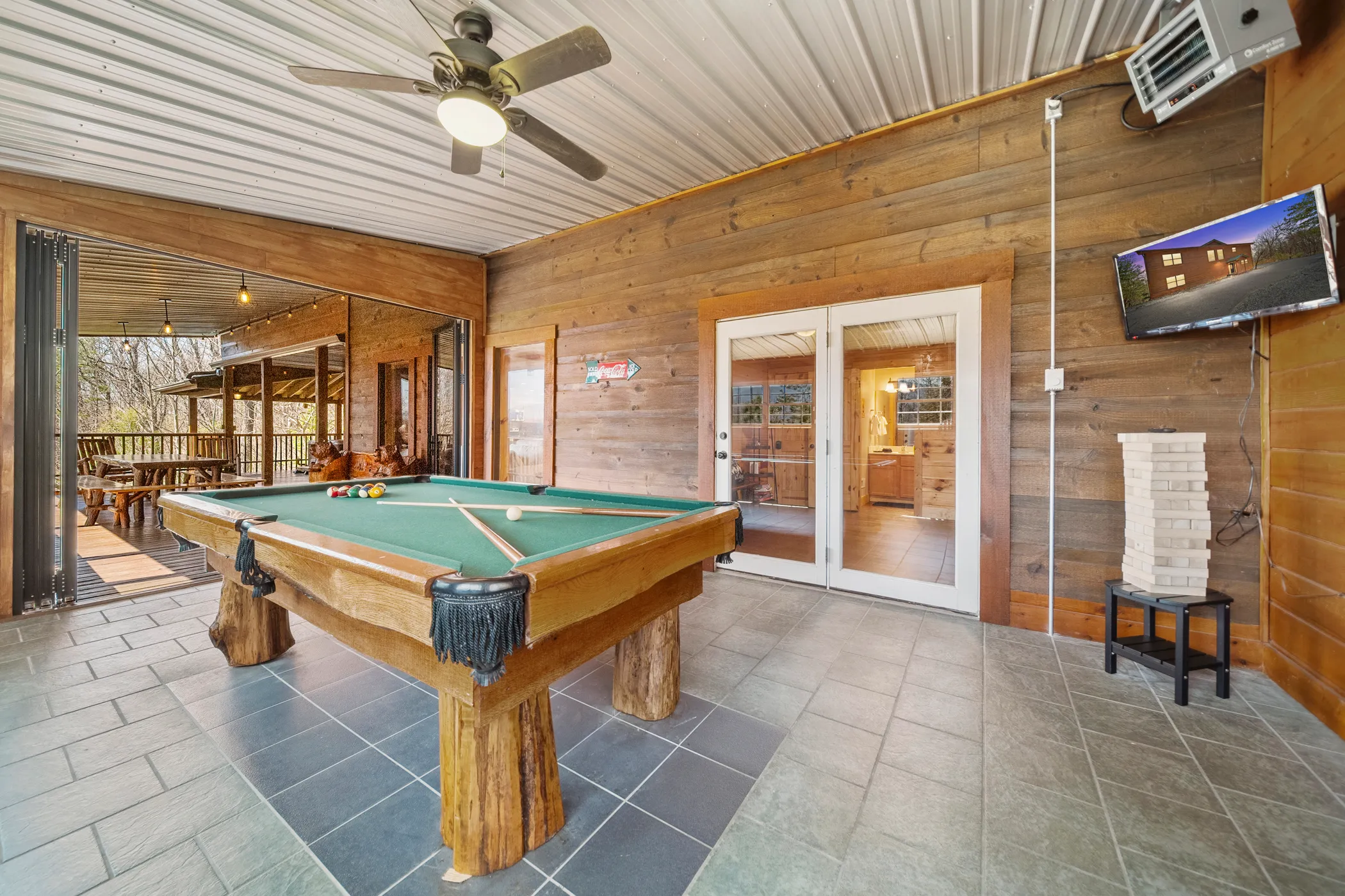 image Game on! Rack up a game of pool in our fun-filled game room, complete with a small TV and bar seating, opening up to the great outdoors.