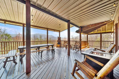 Spacious main deck featuring ample seating, mood lighting, and a propane fire pit—ideal for gatherings and stargazing.