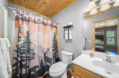 Ensuite bathroom retreat with forest-themed decor that mirrors the great outdoors, complete with a full bathtub for soaking.