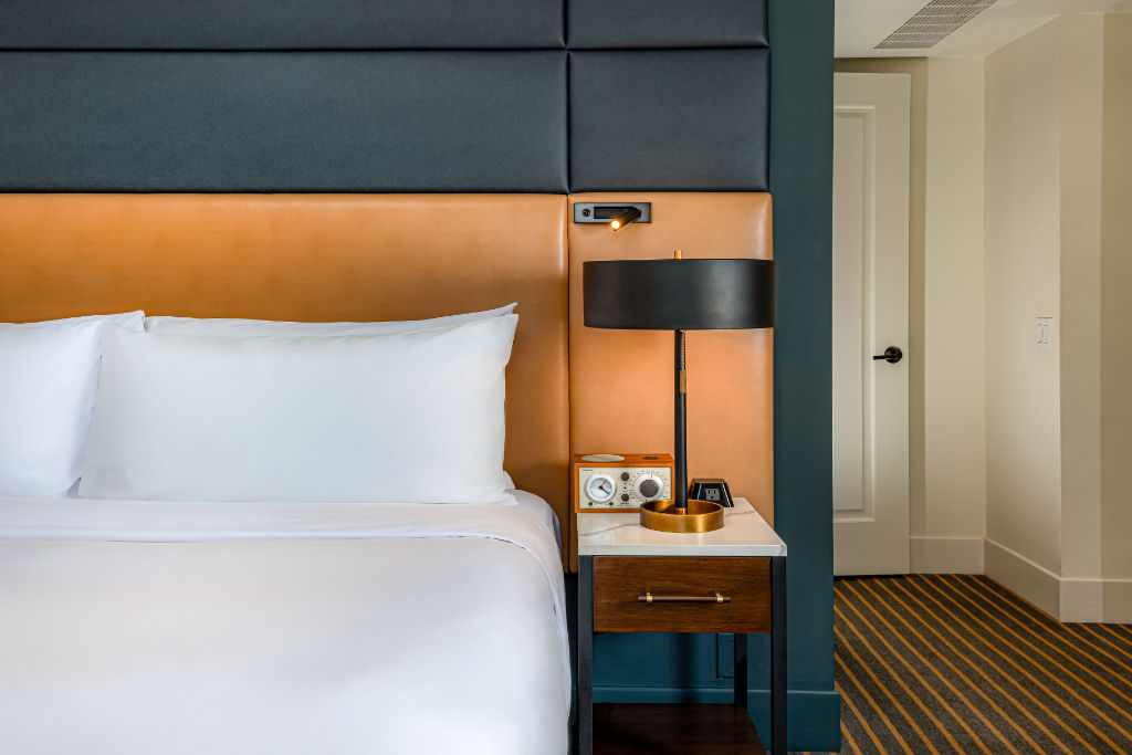 image Modern chic meets comfort with plush bedding in a room accented by vibrant colors.