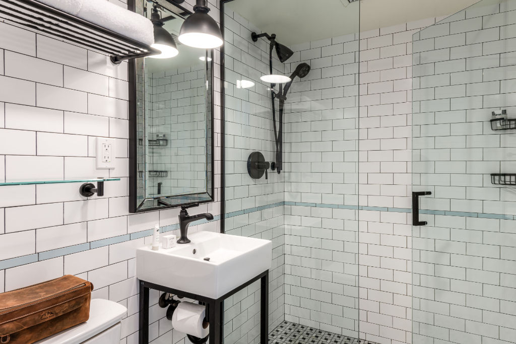image Spacious and industrial chic bathroom featuring subway tiles and a walk-in shower for a refreshing experience.