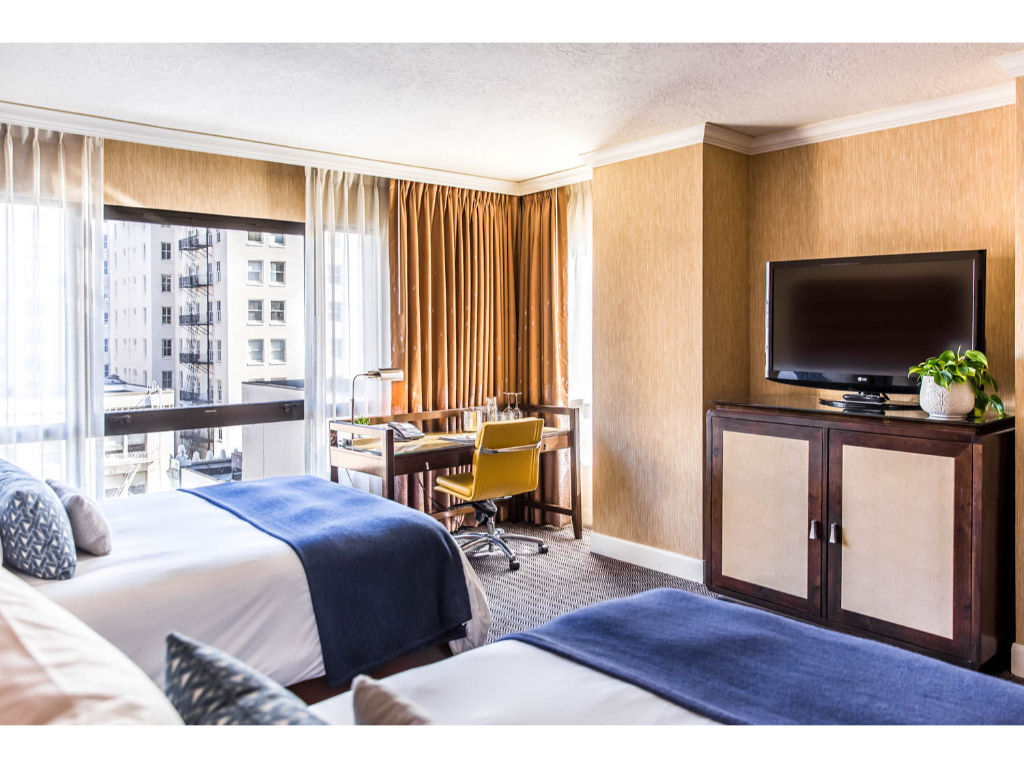 image A serene setting with a plush bed, framed by city views, perfect for rest after exploring.
