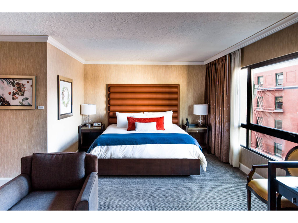 image An elegant room featuring a plush king bed, complete with a cozy seating area and warm, inviting decor.