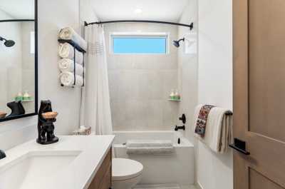 Bright and modern bathroom featuring a sleek vanity, spacious shower, and fresh towels for your convenience.