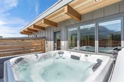 Luxurious hot tub on the upper level deck with sweeping mountain views, perfect for soaking and relaxation.