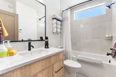 Stylish bathroom featuring a large vanity, spacious tub, and contemporary design for your convenience.