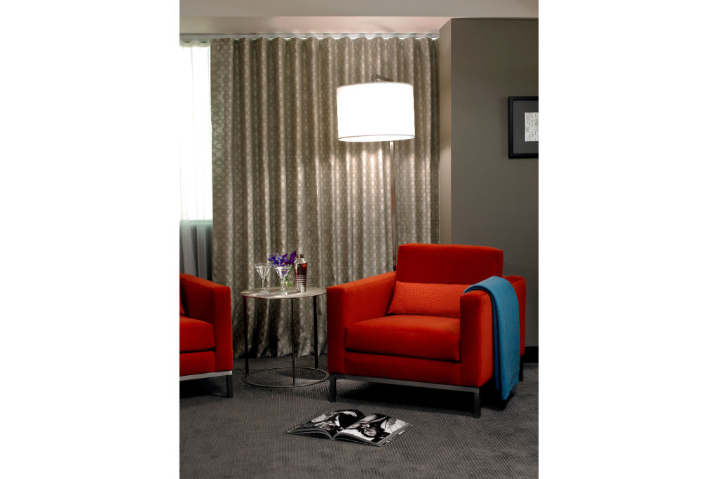 image Cozy up in this vibrant lounge area, featuring plush chairs and a modern setting—ideal for relaxation or catching up on work in style.