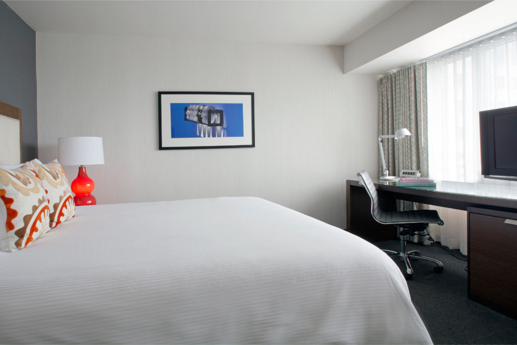 image Unwind in this serene, minimalist bedroom with plush bedding and a tranquil atmosphere, designed to ensure a restorative night's sleep.