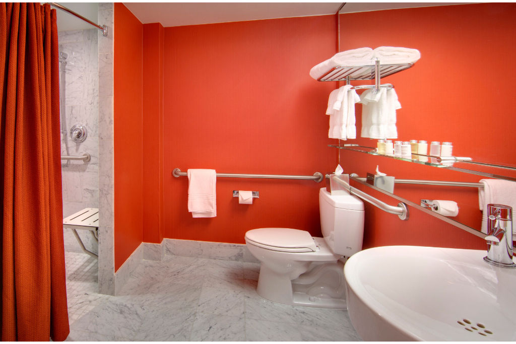 image Refresh in style in this strikingly modern bathroom, boasting bold red decor and top-tier amenities for a luxurious and invigorating morning routine.