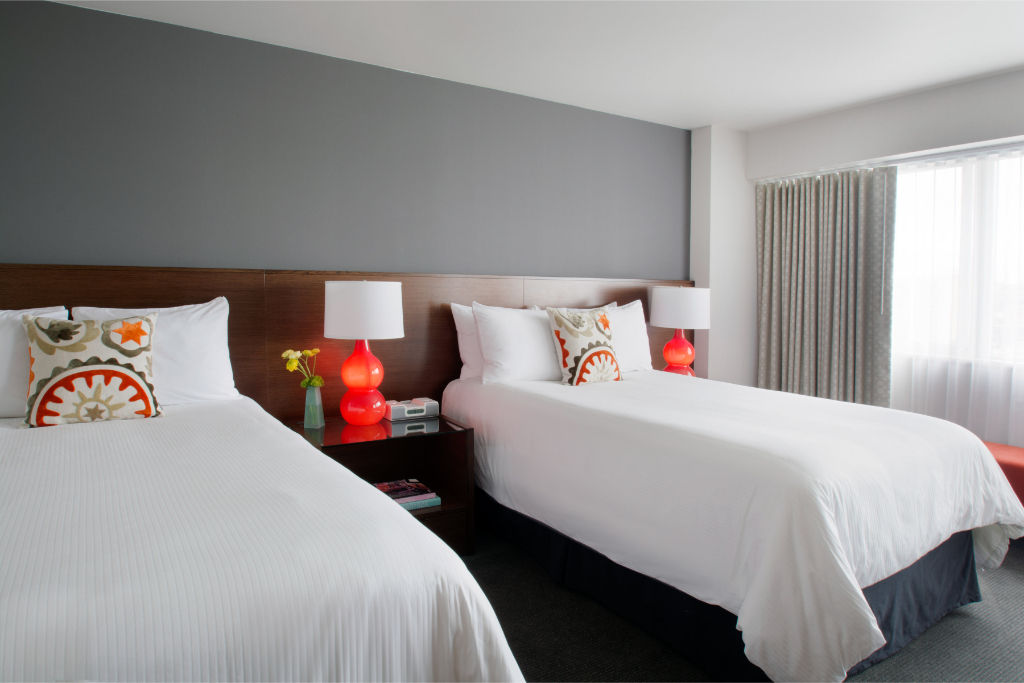 image Spacious and comfortable room featuring plush bedding and vibrant decor, ideal for friends or family seeking a shared yet stylish stay.
