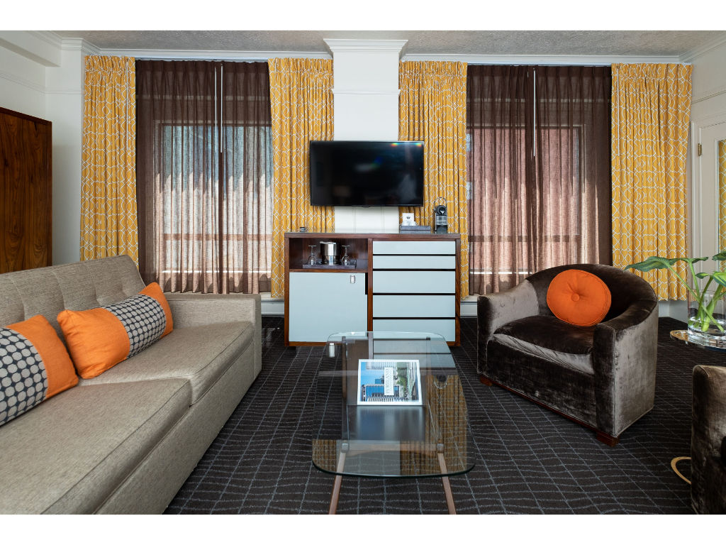 image Contemporary Junior Suite showcasing a king bed, sleek media setup, and a comfortable sofa bed for extra guests.