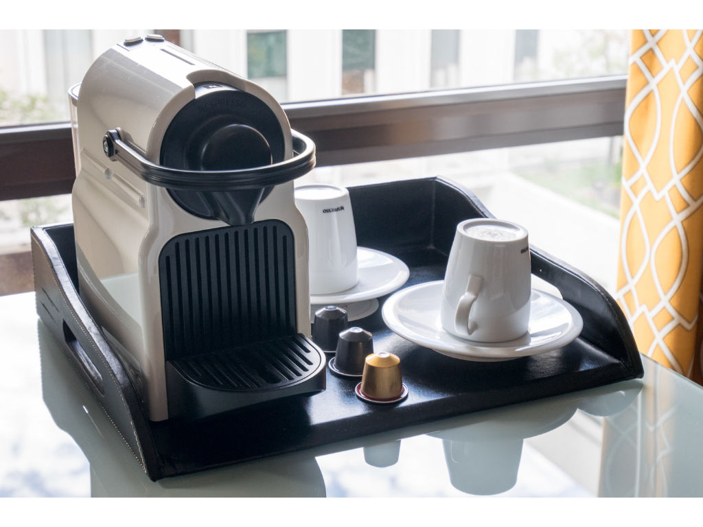 image Enjoy a delightful in-room coffee experience with our sleek machine and well-appointed accessories.