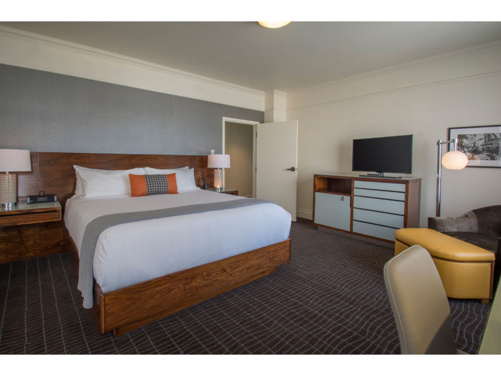 image Spacious Gallery Suite with a comfortable bed and separate seating area, perfect for relaxation or work.