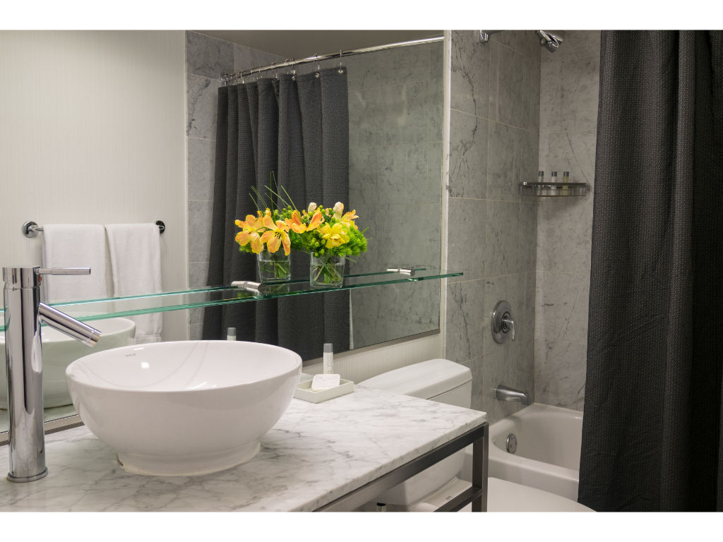 image Contemporary Gallery Suite bathroom with a stylish vessel sink and fresh floral accents, offering a spa-like atmosphere.