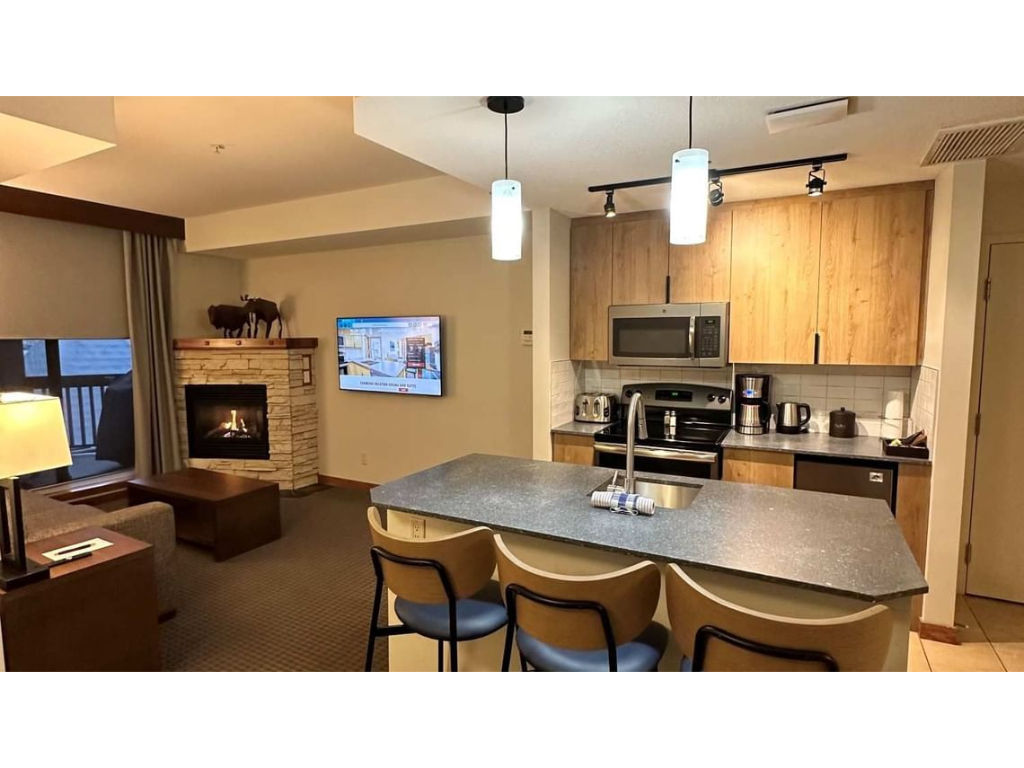 image Inviting kitchen and living area with warm wood tones and a cozy fireplace, creating a welcoming atmosphere.
