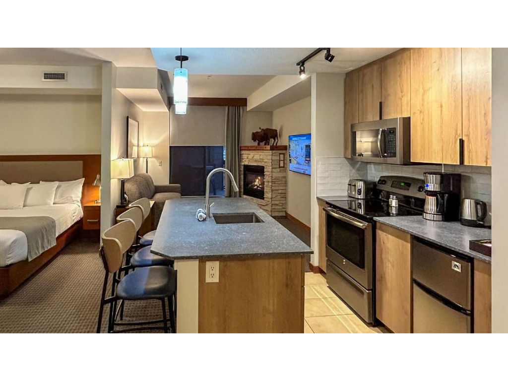 image Stylish open-concept kitchen with modern appliances and a spacious island, seamlessly flowing into the cozy living and sleeping areas.