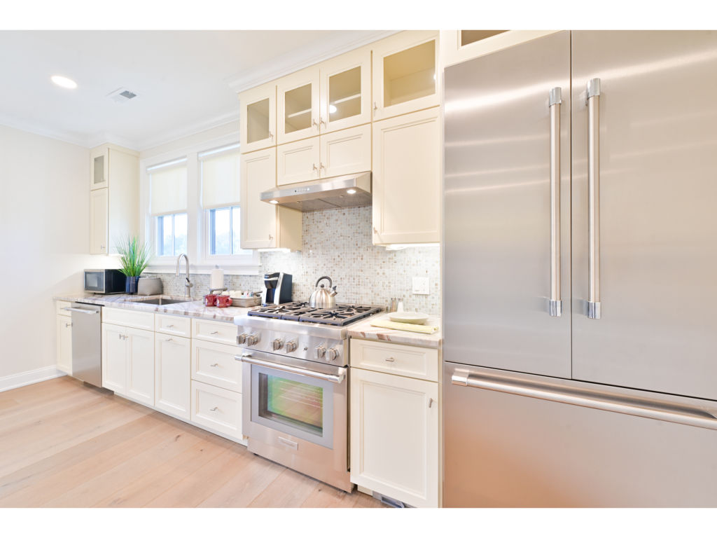 image Modern kitchen with high-end stainless steel appliances, sleek cabinetry, and ample counter space for cooking and entertaining.
