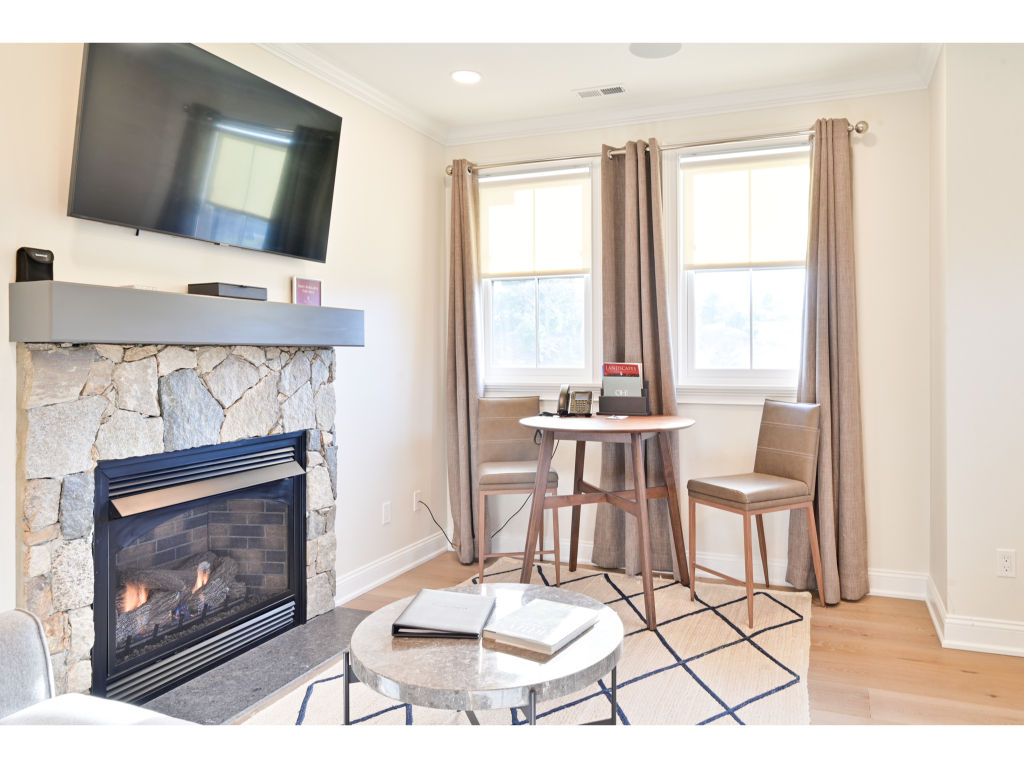 image Cozy living area with a fireplace, flat-screen TV, and a small dining table, perfect for relaxing and enjoying meals.