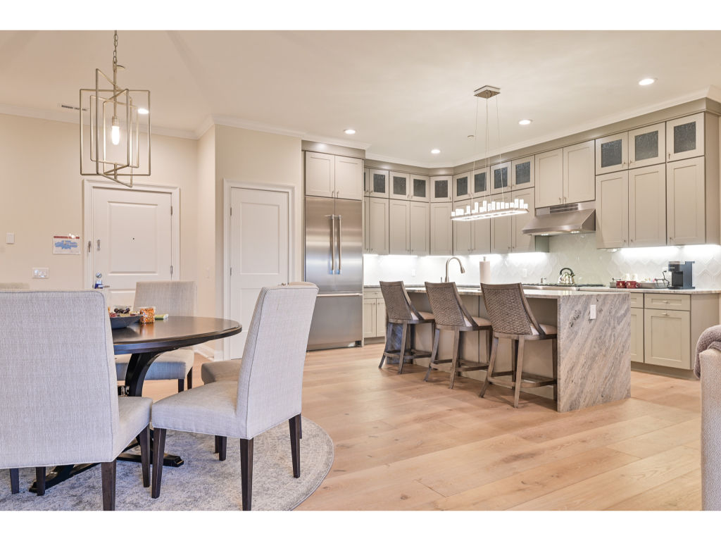 image Modern kitchen and dining area featuring high-end appliances, elegant decor, and ample seating for meals and gatherings.