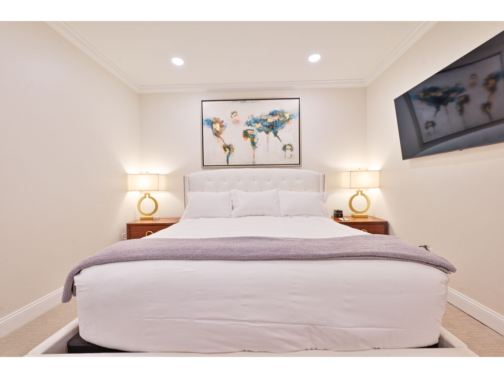 image Serene bedroom with a comfortable king bed, soft lighting, and a flat-screen TV for a restful night's sleep.