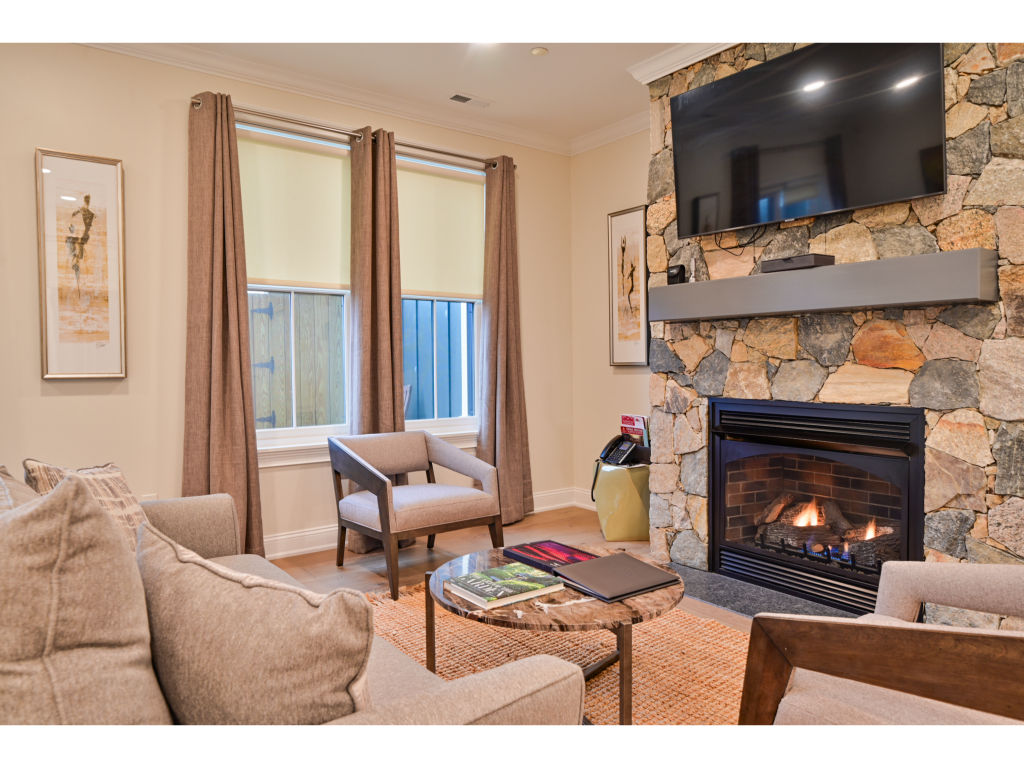 image Cozy living room with a stone fireplace, comfortable seating, and a flat-screen TV for a warm and inviting atmosphere.