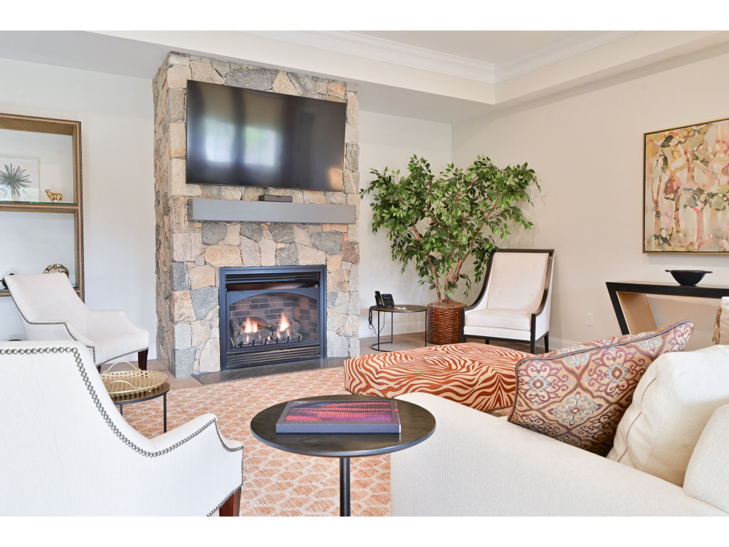 image Cozy living room with a stone fireplace, comfortable seating, and tasteful decor for a warm and inviting atmosphere.