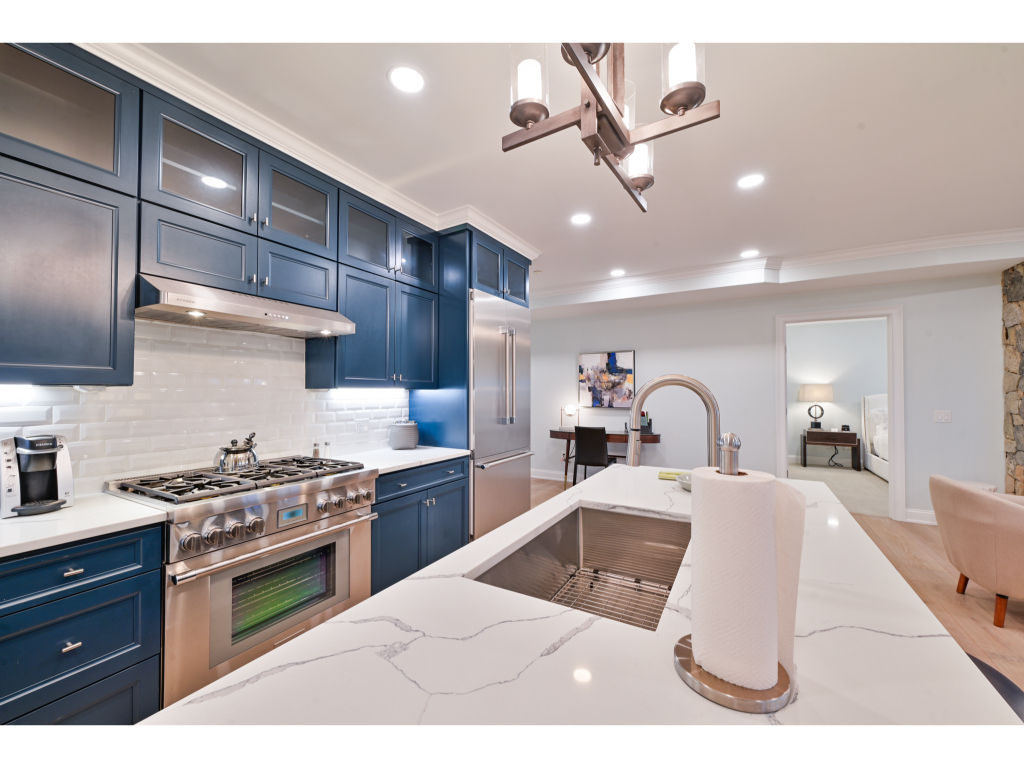 image Modern kitchen featuring stainless steel appliances and a spacious island - ideal for home-cooked meals.